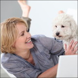 mature woman and dog on floor with laptop