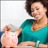 Woman putting coin into piggy bank