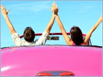 pink convertable and happy couple on road trip